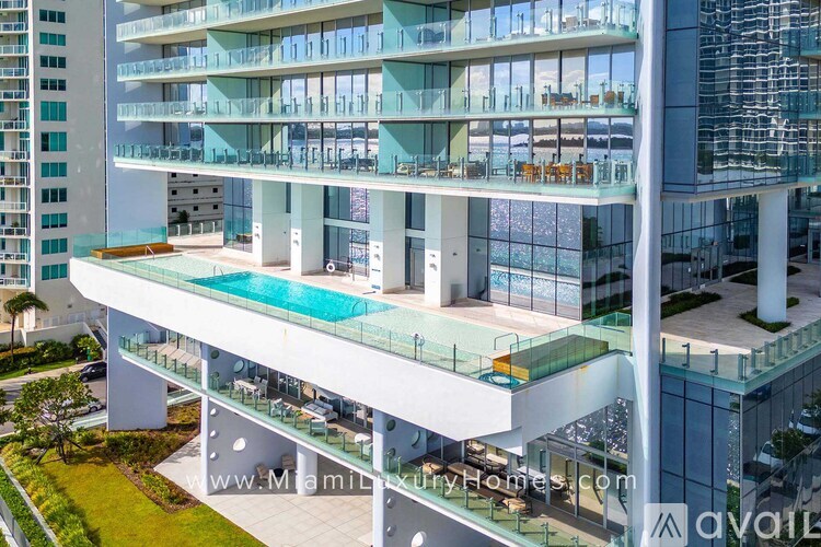A modern multi-level residential building with a pool on the lower level.