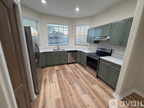 A kitchen with wooden floors and green cabinets.