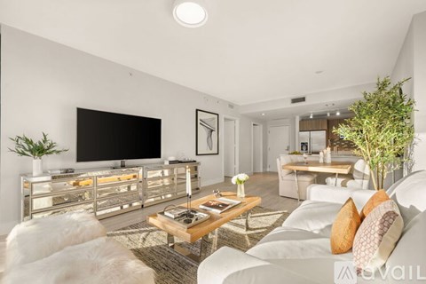 A modern living room with a white couch and a wooden coffee table.