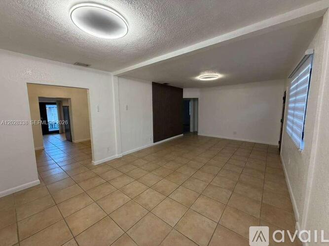 A spacious room with tiled flooring and a ceiling light fixture.