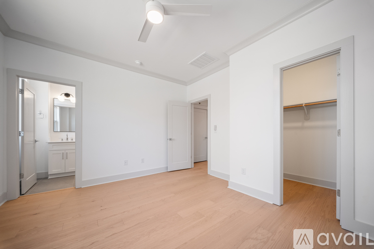 A spacious, empty room with wooden floors and white walls.