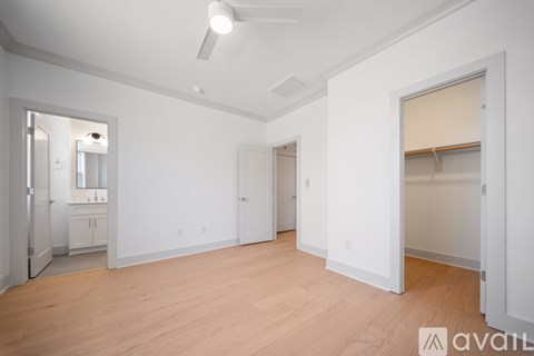 A spacious, empty room with wooden floors and white walls.