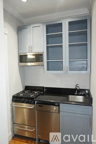 A kitchen with a stove top oven, microwave, and sink.