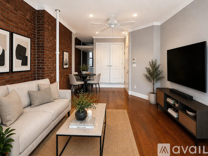 A living room with a brick wall and a white couch.