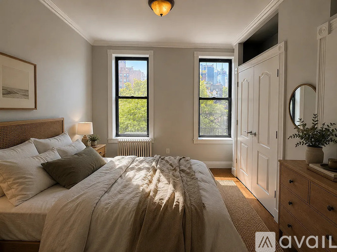 A bedroom with a large bed and a window with a view of a building outside.