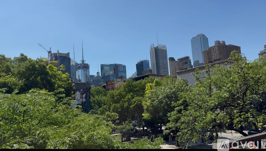 A cityscape with buildings and trees in the foreground.