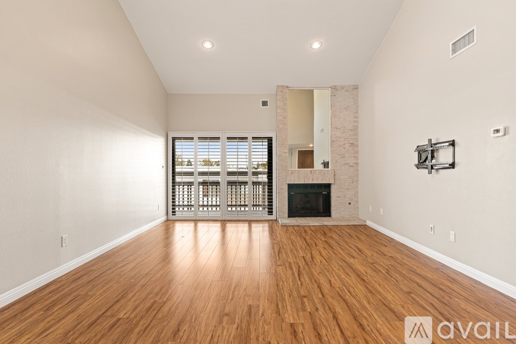 A spacious living room with hardwood floors and a fireplace.
