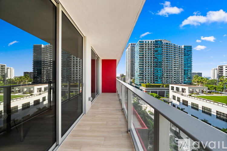 A balcony with a red door and a view of buildings.