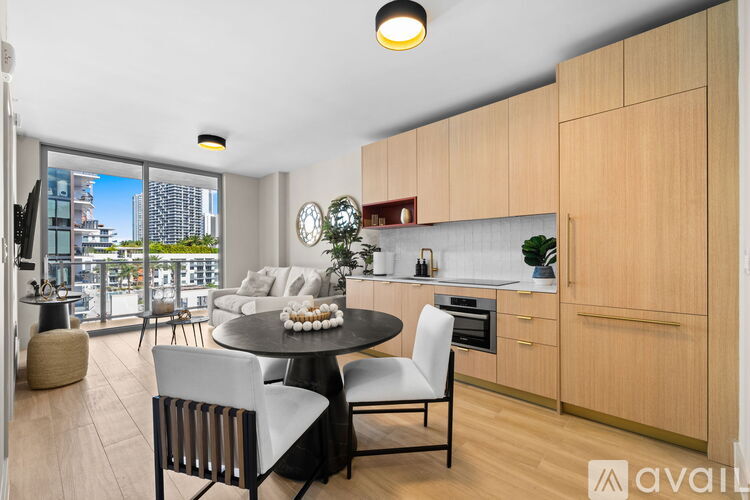 A modern kitchen with wooden cabinets and a dining table with chairs.