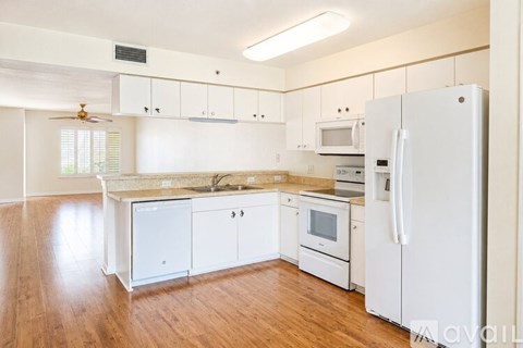 A kitchen with white appliances and cabinets.