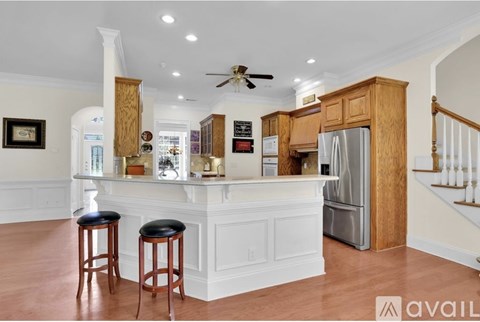 A kitchen with a white island and wooden cabinets.