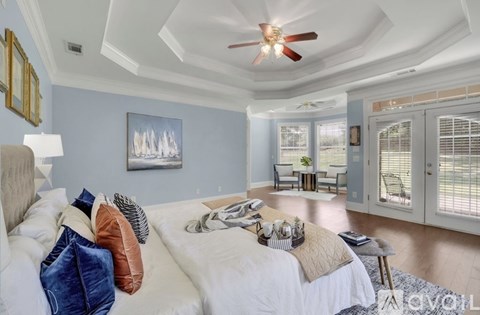 A bedroom with a bed, pillows, and a ceiling fan.