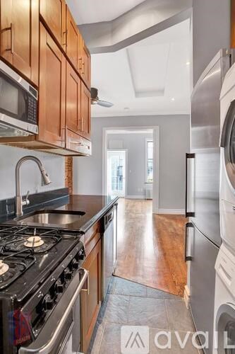 A kitchen with wooden cabinets and a black stove top.