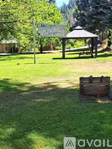 A sign for Wilderness Lodge stands in a grassy area.