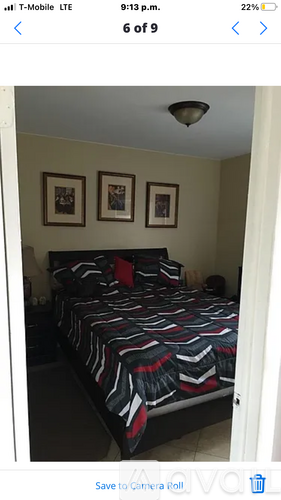 A bedroom with a bed and two pictures on the wall.