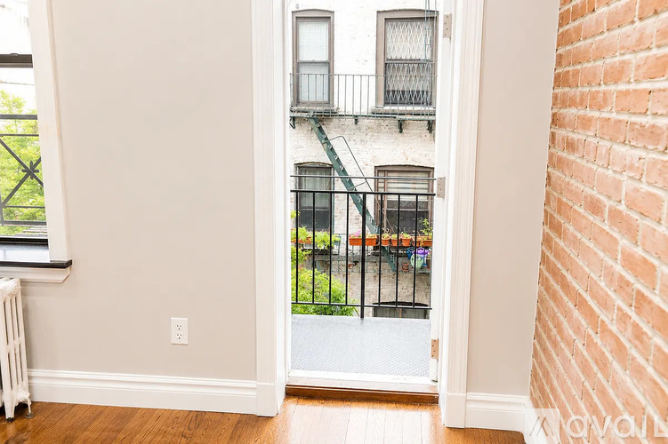 A view of a balcony from a room with a door open.