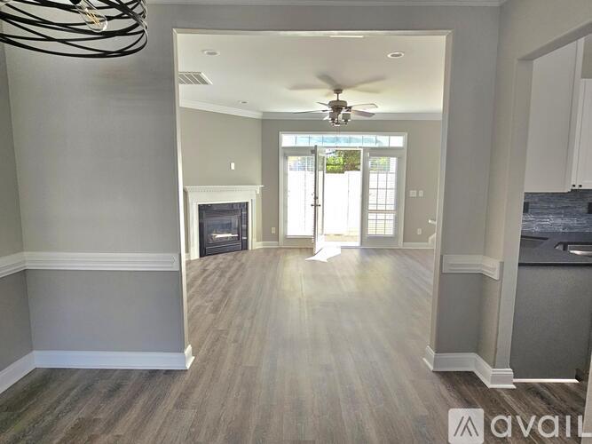 A spacious living room with a fireplace and a ceiling fan.
