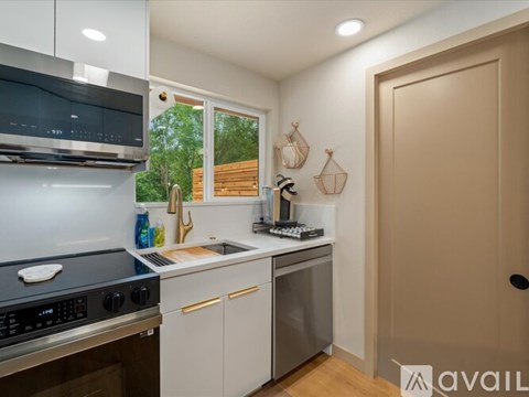 A kitchen with a black stove top oven and a white dishwasher.