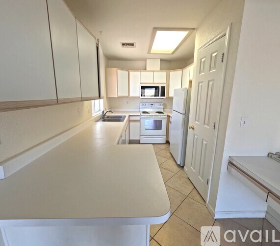A kitchen with white cabinets and appliances.