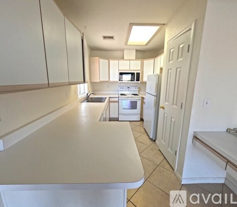 A kitchen with white cabinets and appliances.