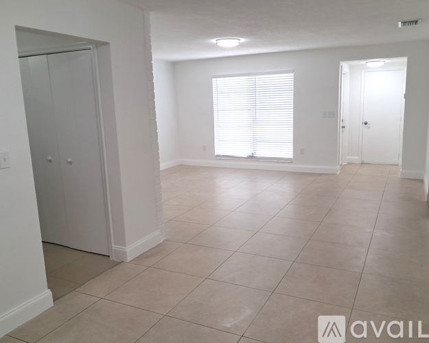A spacious room with tiled flooring and white walls.