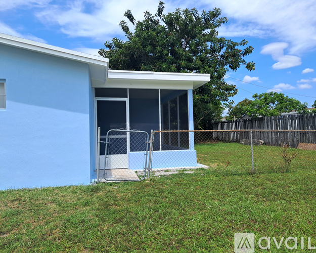 A small blue building with a white roof and a fence around it.