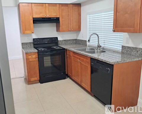 A kitchen with wooden cabinets and a black oven.