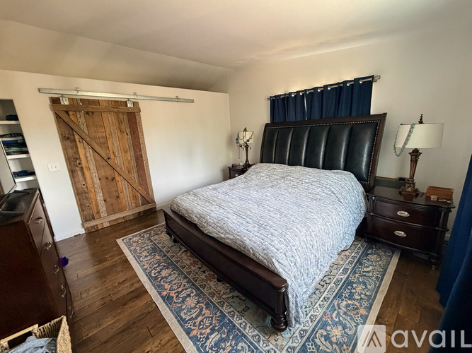 A bedroom with a large bed and a wooden door.