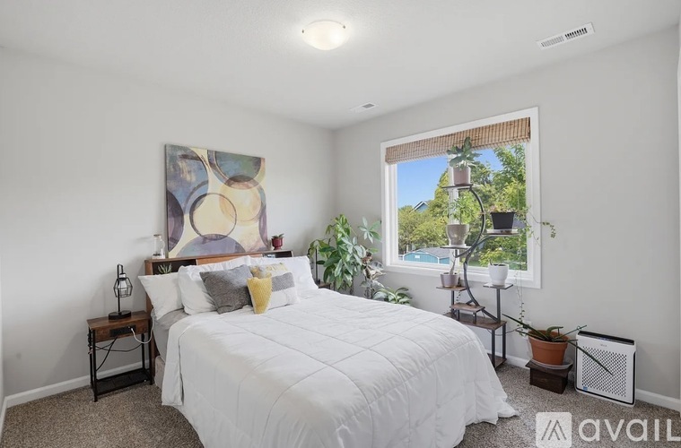 A bedroom with a large bed and a painting on the wall.