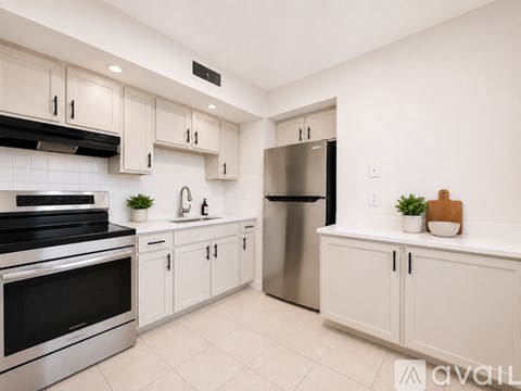 A modern kitchen with stainless steel appliances and white cabinets.