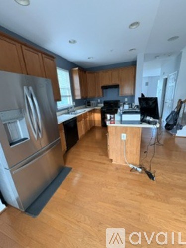 A kitchen with wooden cabinets and a stainless steel refrigerator.
