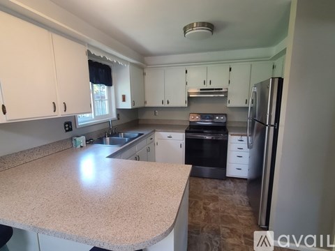 A kitchen with a granite counter top and stainless steel appliances.