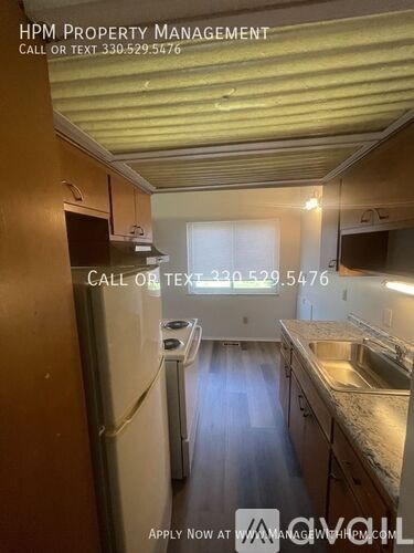 A kitchen with a refrigerator, sink, and cabinets is shown in the image.