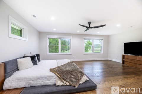 A bedroom with a large bed and a ceiling fan.
