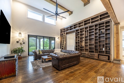 A living room with a large couch and a wooden floor.