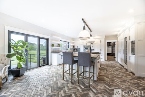A kitchen with a herringbone patterned floor and a dining table with chairs.