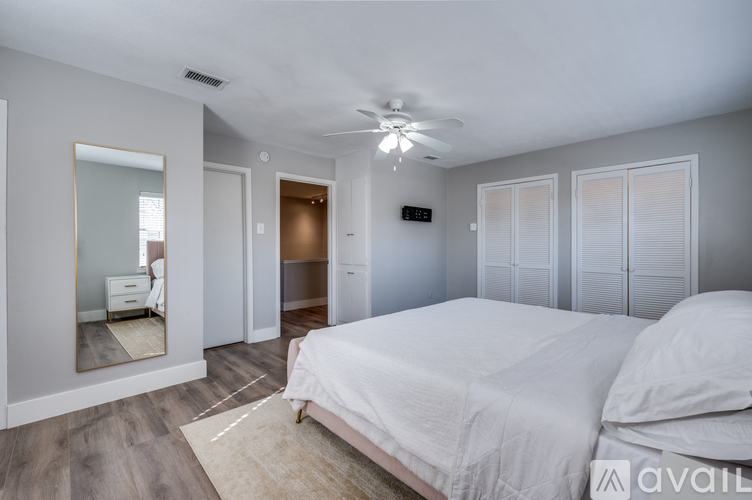 A bedroom with a large bed and a mirror on the wall.