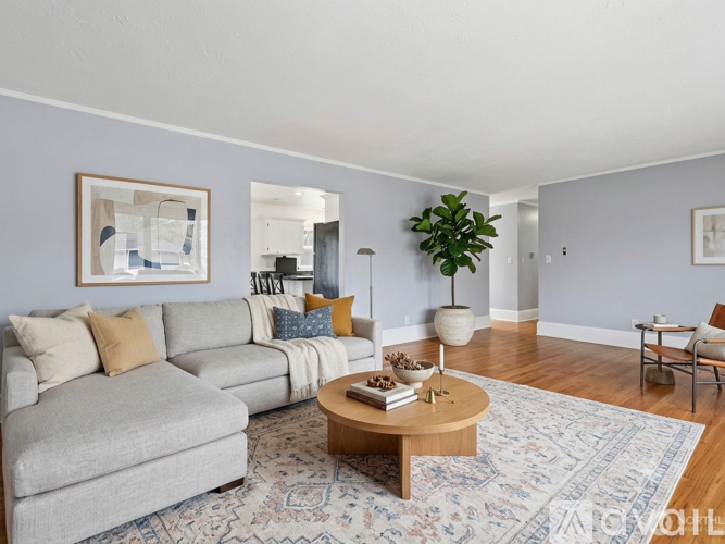 A living room with a grey couch, a coffee table, and a rug.