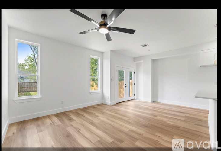 A room with a ceiling fan and wooden flooring.