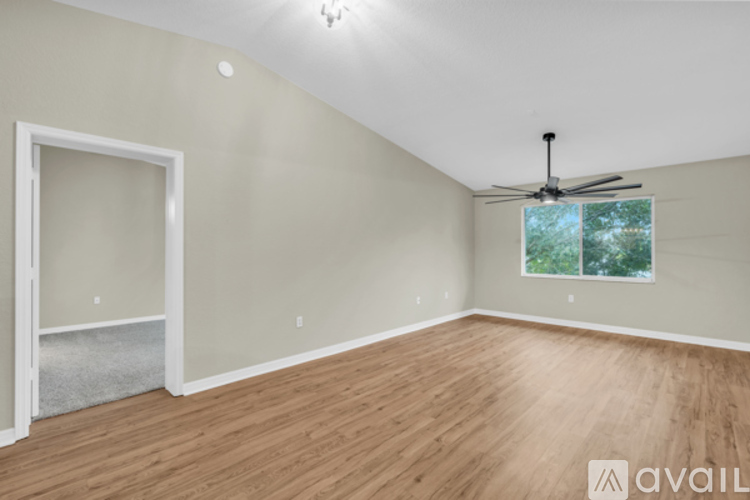 A room with wooden flooring and a ceiling fan.