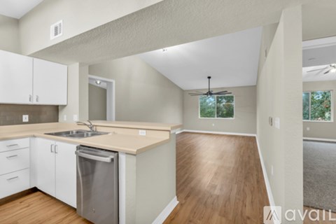 A kitchen with white cabinets and a wooden floor.