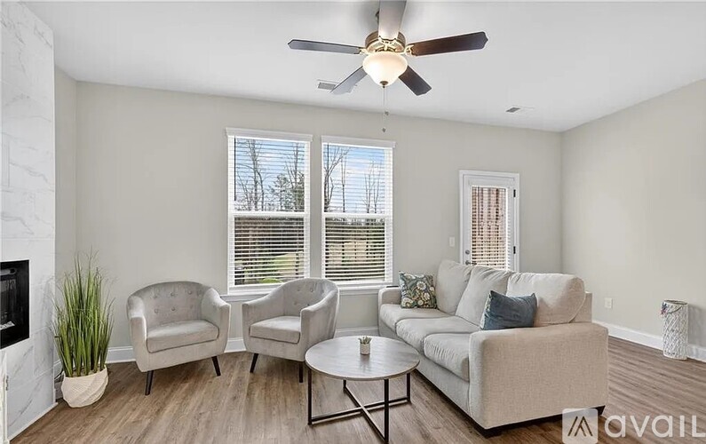A living room with a fireplace, two chairs, a couch, and a coffee table.