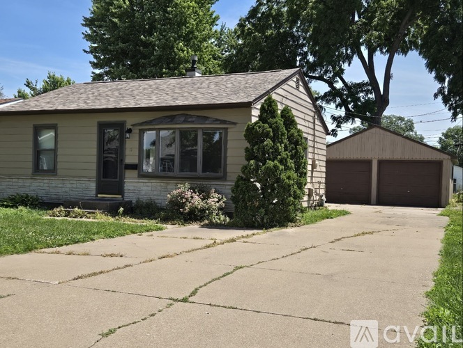A house with a garage and a driveway in front.