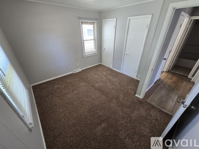A room with brown carpet and white walls.