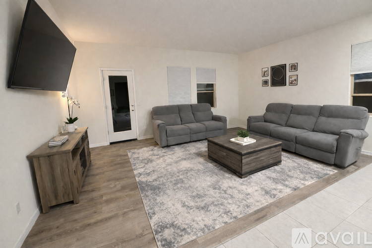 A living room with grey furniture and a wooden cabinet.