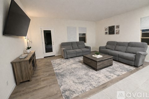 A living room with grey furniture and a wooden cabinet.