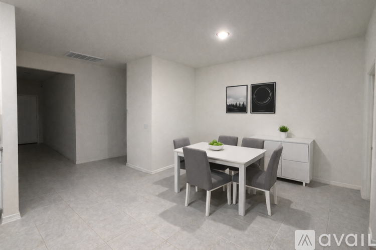 A dining room with a table set for two and a potted plant on the side table.