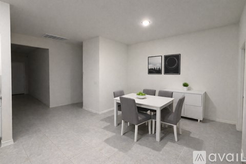 A dining room with a table set for two and a potted plant on the side table.