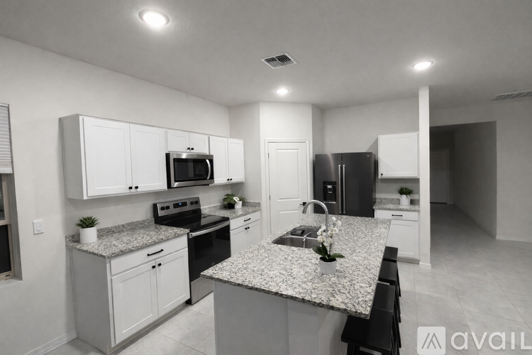 A kitchen with granite countertops and white cabinets.