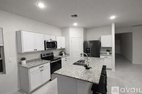 A kitchen with granite countertops and white cabinets.